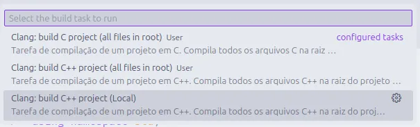 Visual Studio Code com o painel de tarefas aberto, mostrando a tarefa "Clang: build C++ project (Local)" selecionada.